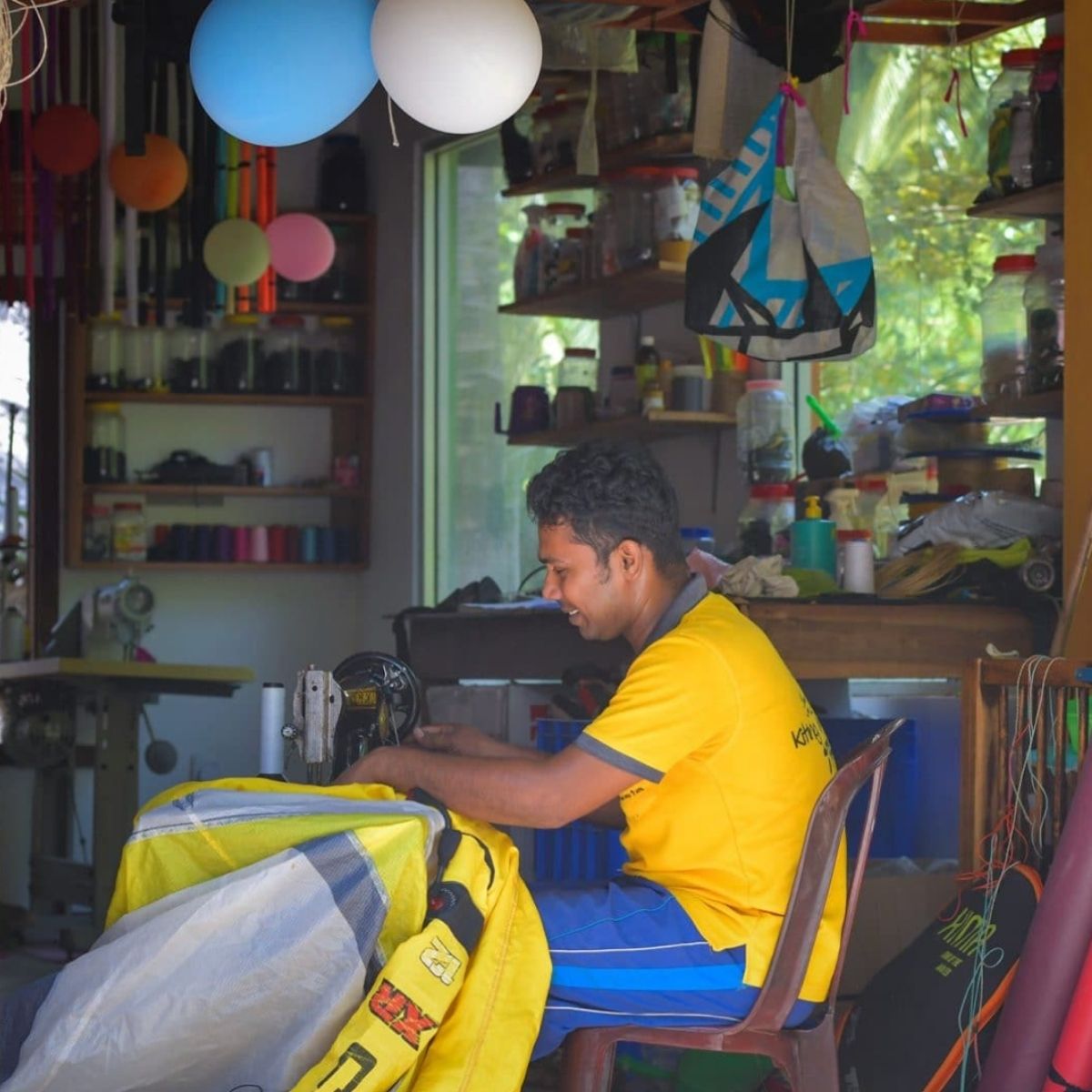 Nishanta sewing a kitesurfing sail in his repair workshop in Sri Lanka
