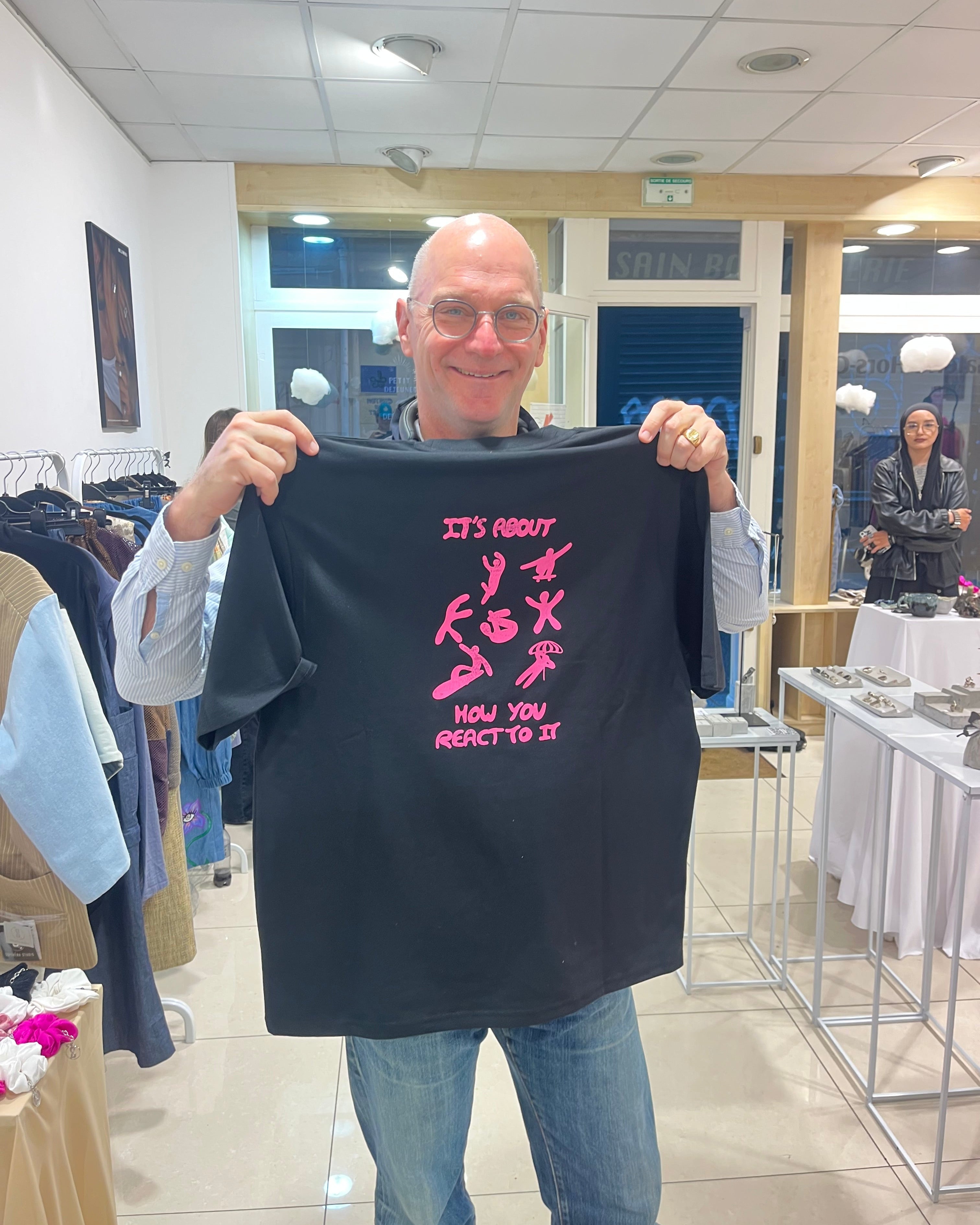 Proud customer displaying custom screenprinted black recycled t-shirt at UPWIND Paris event