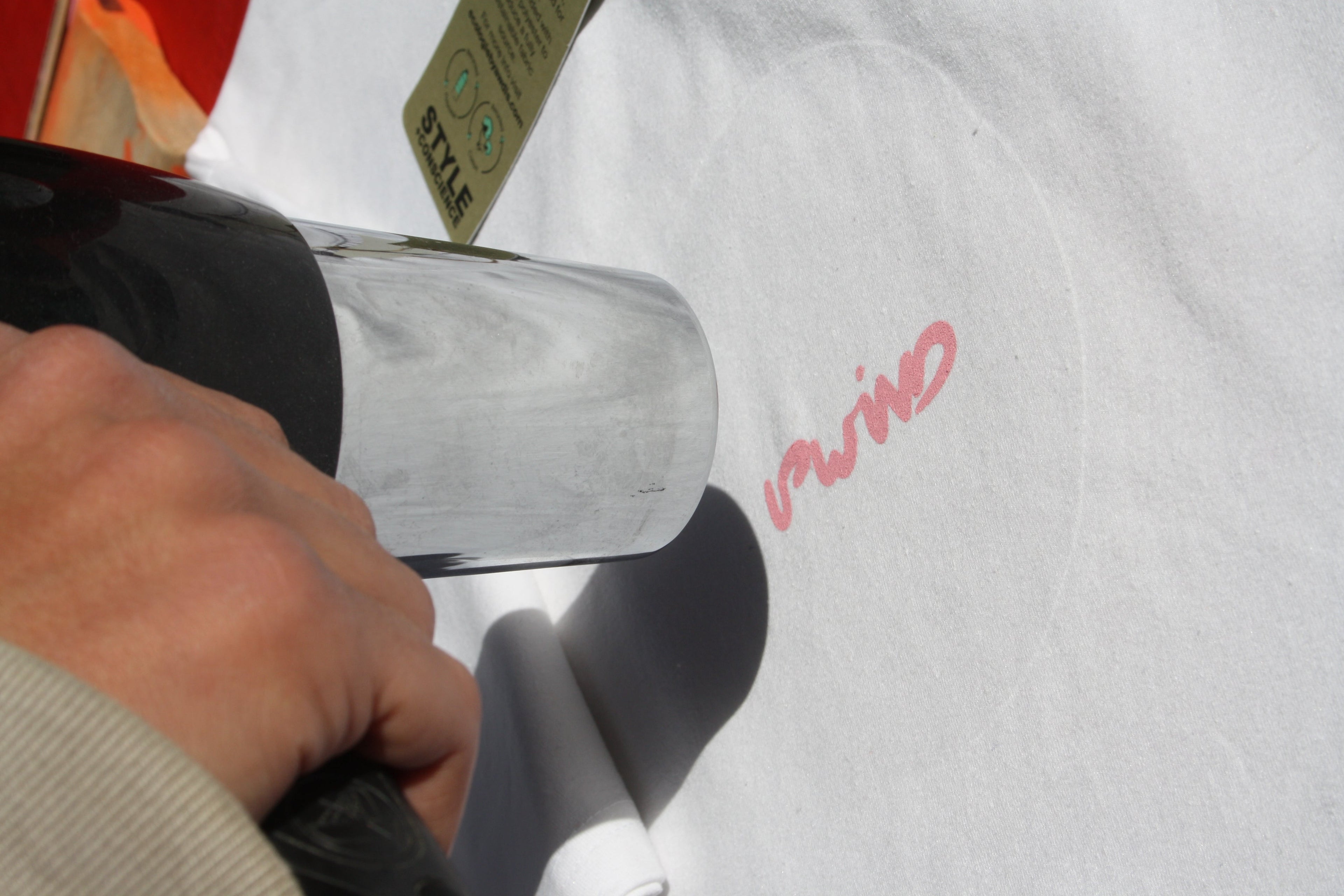 Screenprinting heat drying UPWIND design onto a recycled t-shirt at a live serigraphy workshop