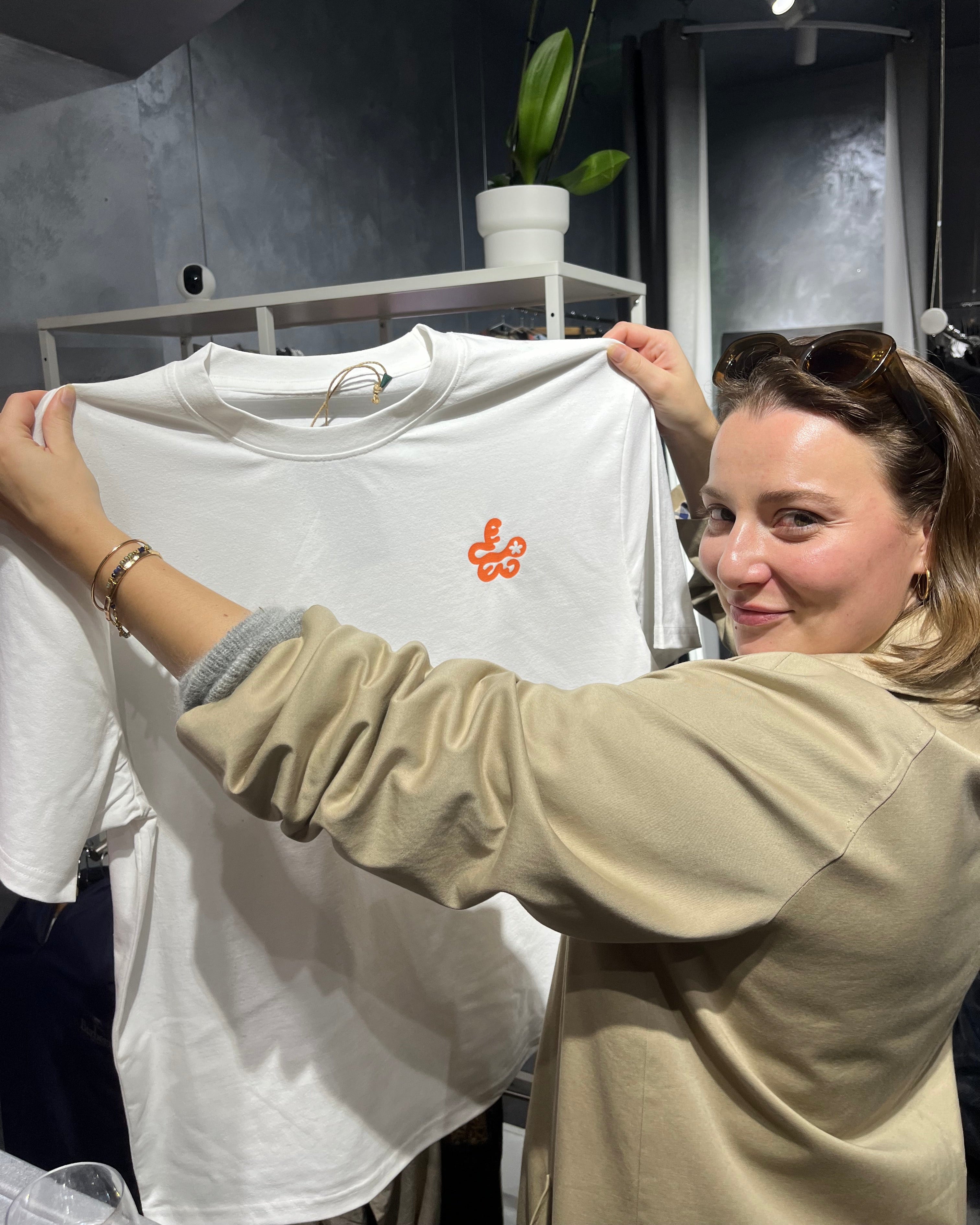 Happy participant holding her freshly screenprinted white recycled t-shirt at UPWIND event